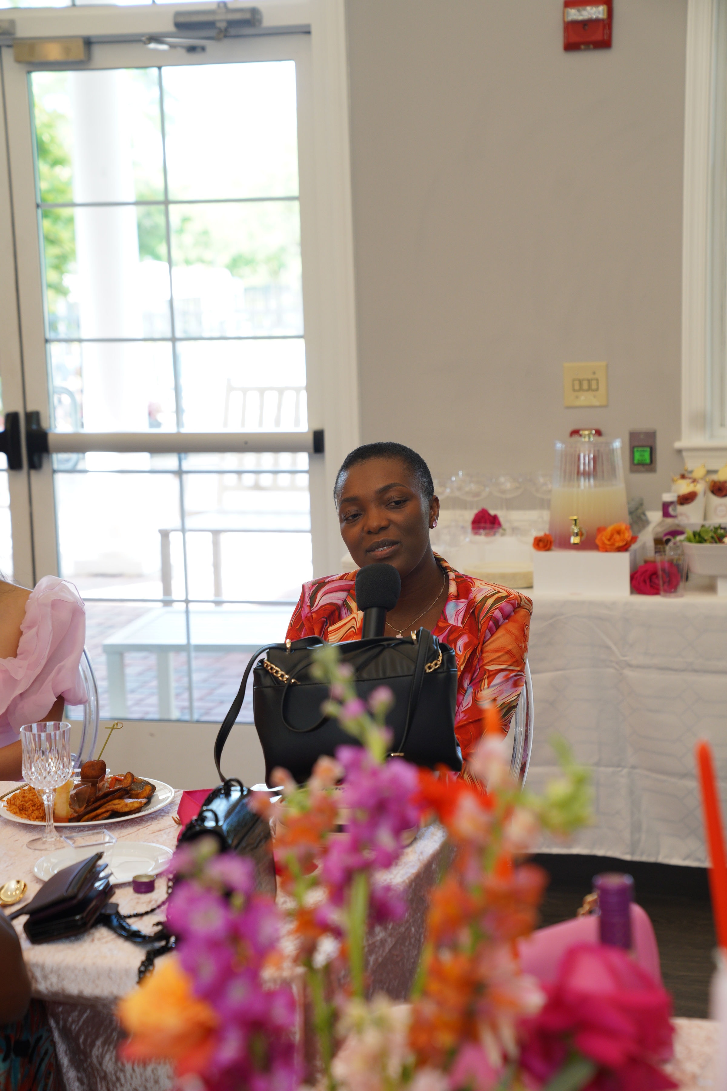 Dr. Angel Mbome speaking at the table during the Bloom event