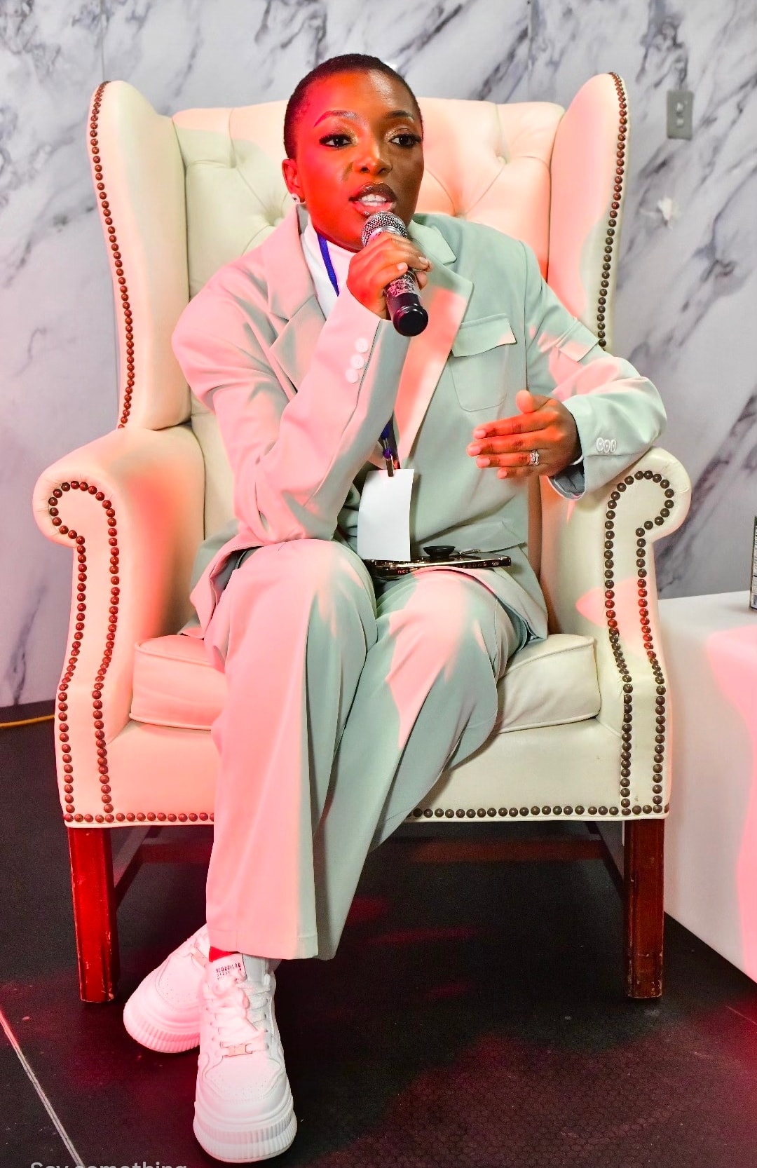 Dr. Angel Mbome speaking on stage at the Empower Diaspora Summit panel